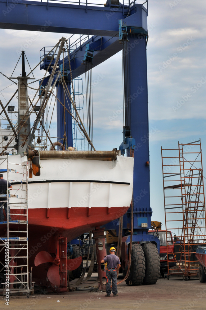 Operai riparano peschereccio in cantiere navale