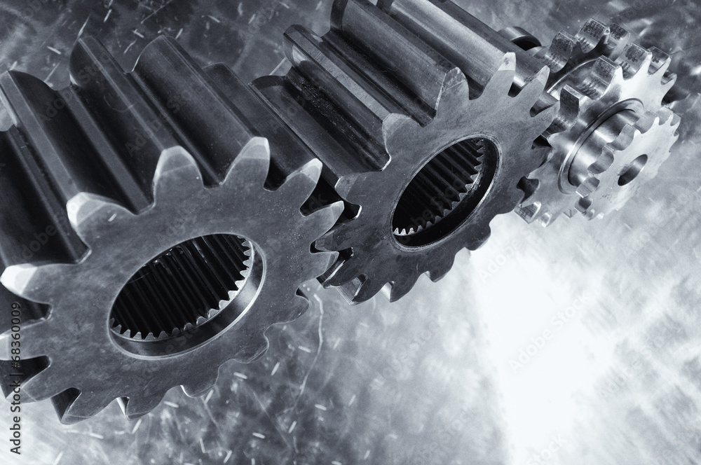 titanium and steel gears and cogs against brushed aluminum titanium and steel gears and cogs against brushed aluminum