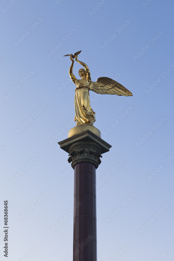 Fototapeta premium Скульптура Добрый ангел мира в лучах заходящего солнца