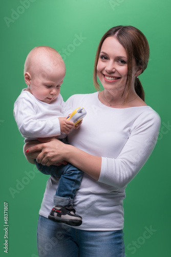 Mother holding toddler son with toy phone