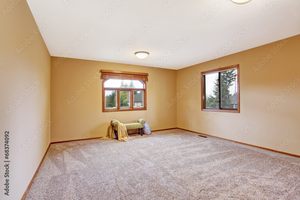 Fototapeta premium Empty bedroom interior in soft peach color with ottoman