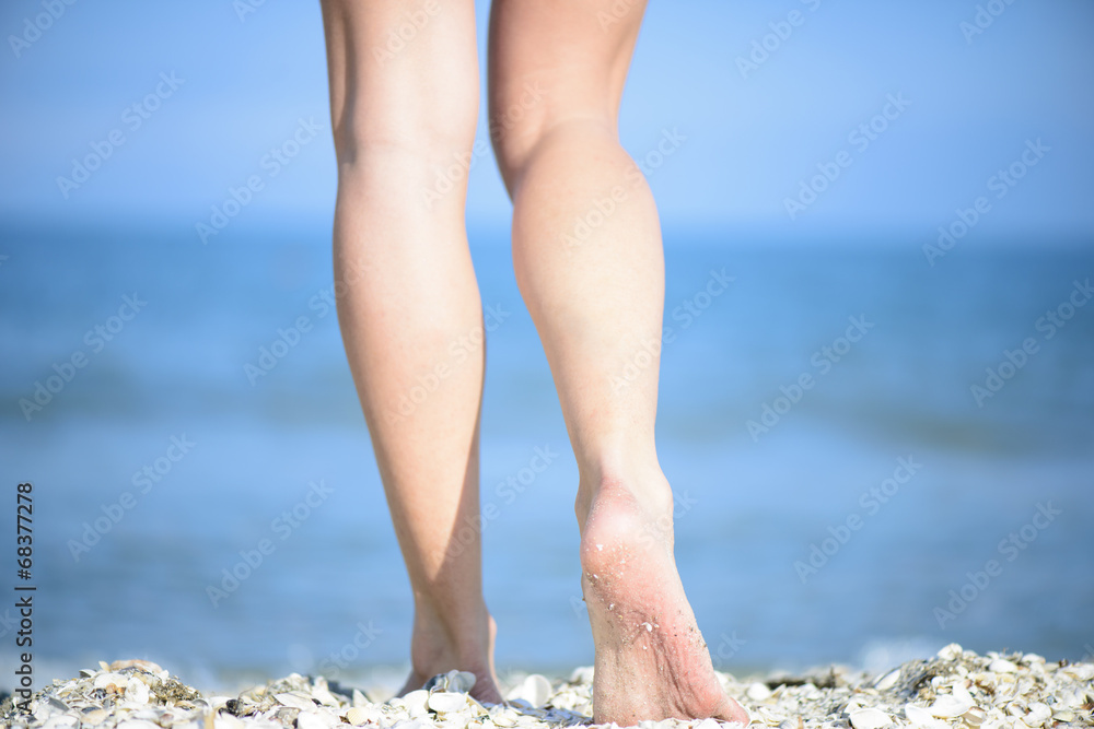 Women's beautiful smooth legs on the beach Women's beautiful smooth legs on the beach