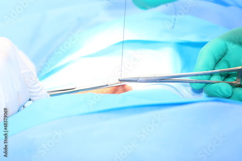 Doctor suturing open wound