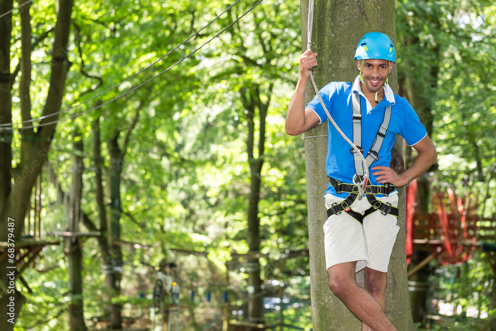 Man poses on platform at high rope course Man poses on platform at high rope course