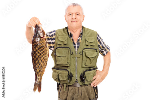 Smiling mature fisherman holding a big fish