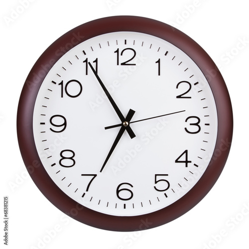 Round clock shows five minutes to seven