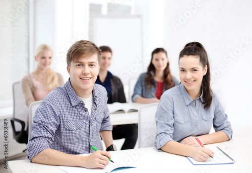 smiling students with notebooks at school