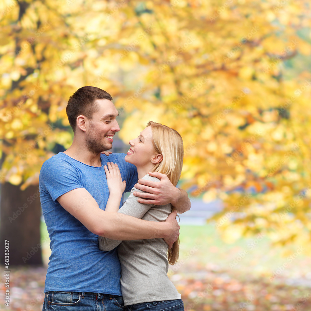 smiling couple hugging and looking at each other smiling couple hugging and looking at each other