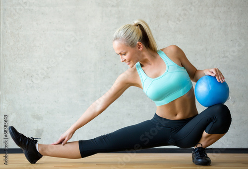 smiling woman with exercise ball in gym