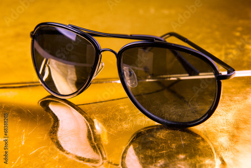 Luxury aviator sunglasses on golden background