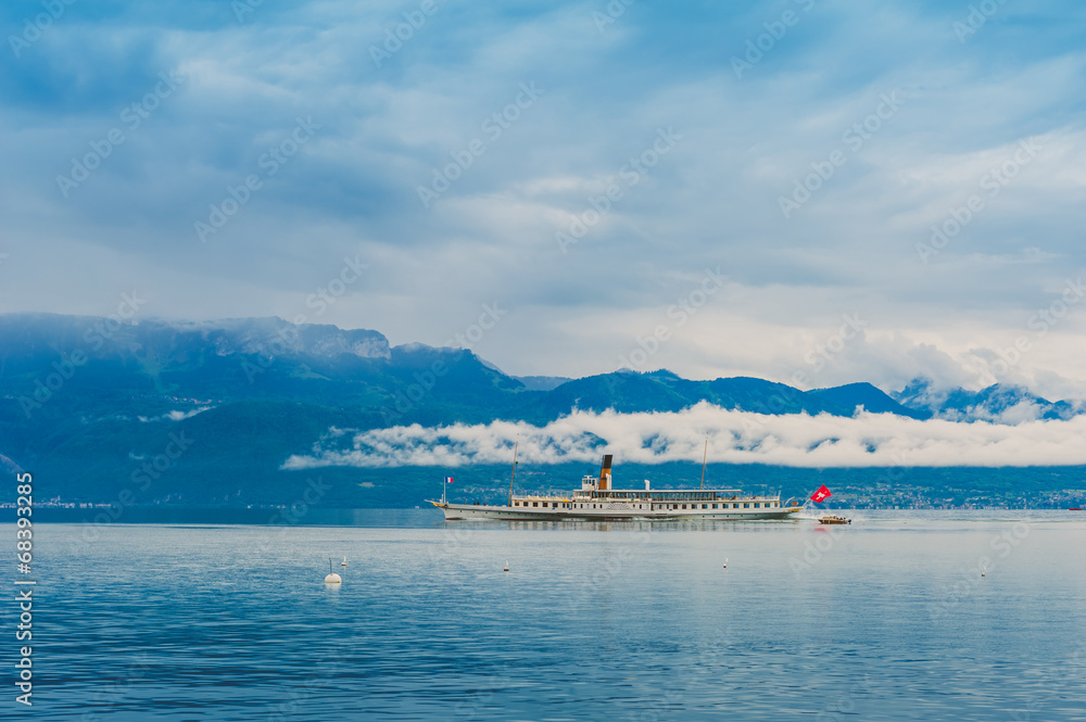 Steam boat with swiss flag floating on the lake Geneva