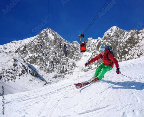 Skier against cable-lift in high mountains