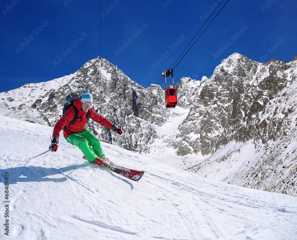 Skier against blue sky in high mountains