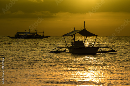 Philippine tourist boat sails on the sea at sunset.