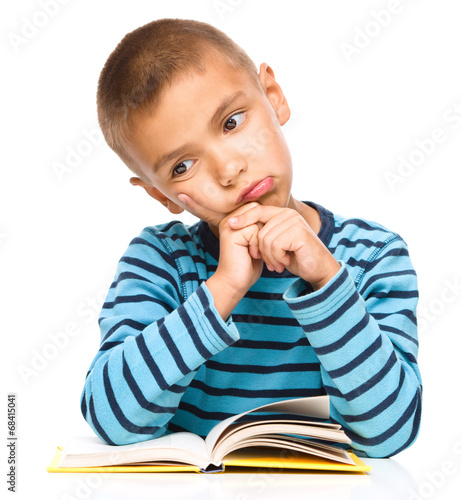 Little boy is tired to read his book