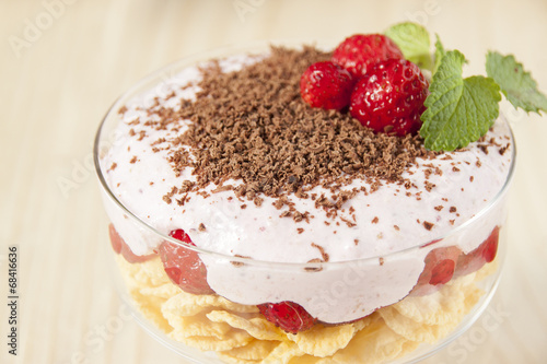 Dessert with curd cream, cereal, strawberries and chocolate.