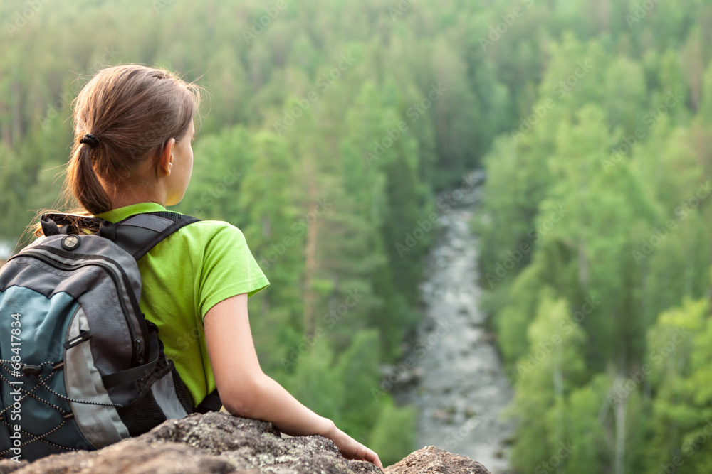 Young backpacker looking into the distance from mountain peak