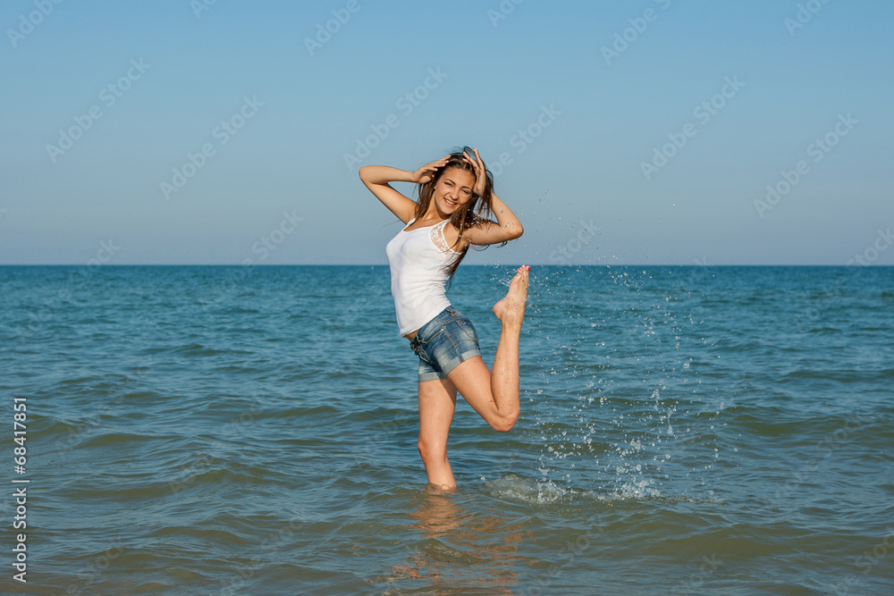 young girl splashing the water in the sea