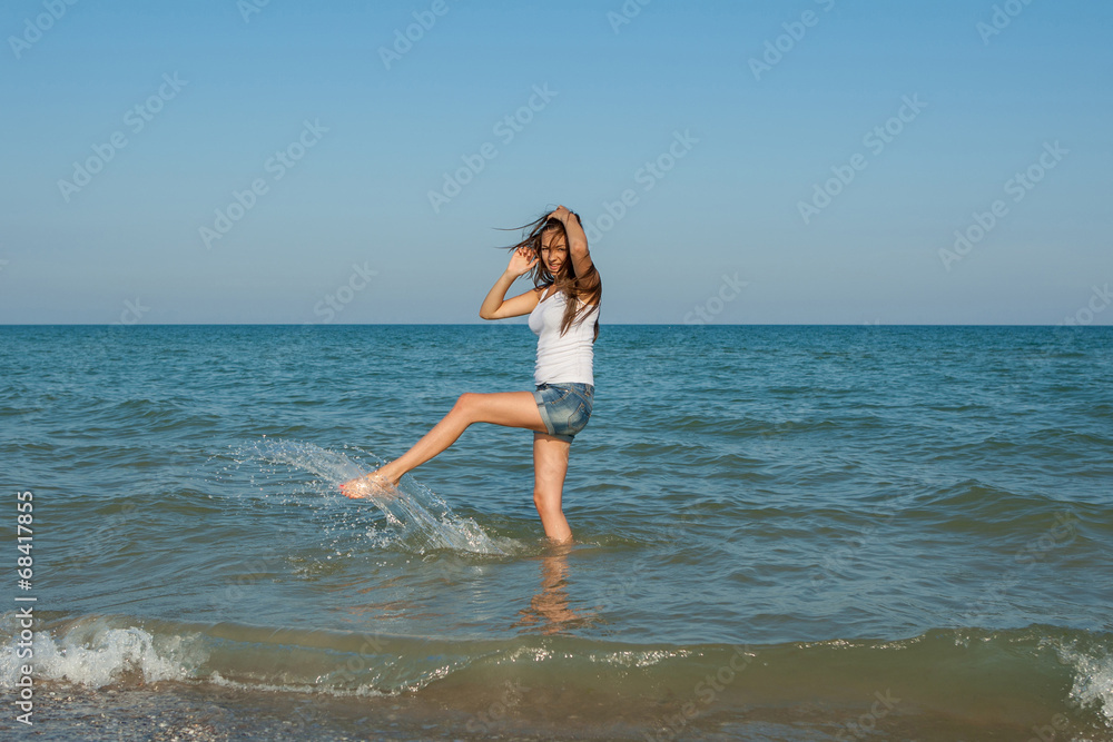 young girl splashing the water in the sea young girl splashing the water in the sea