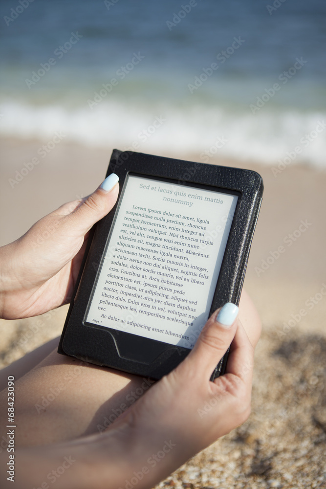 reading ebook reader on a beach 