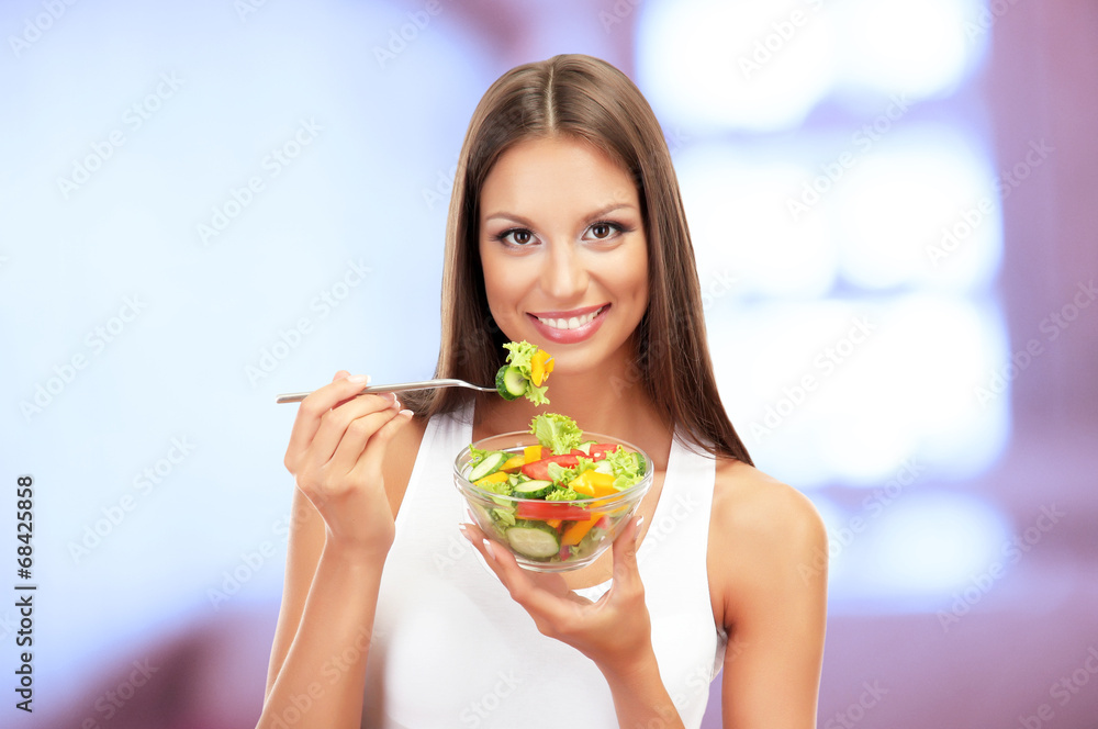 Beautiful young woman with salad on interior background Beautiful young woman with salad on interior background