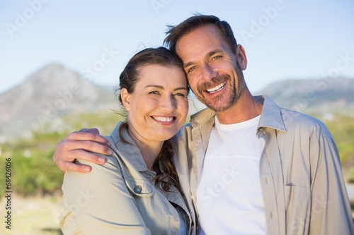 Hiking couple smiling at camera in the countryside