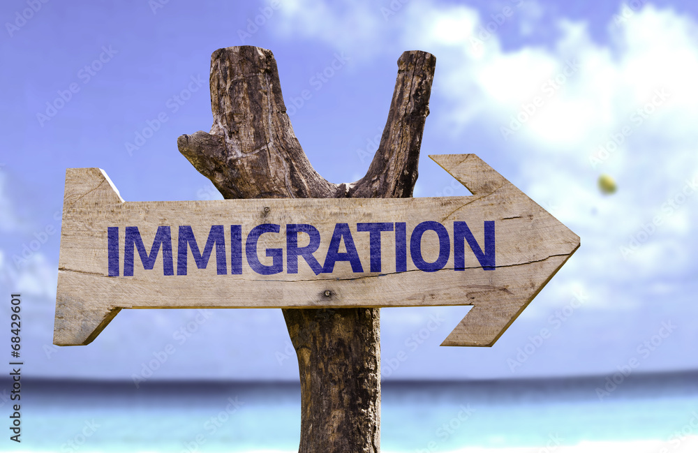 Immigration wooden sign with a beach on background