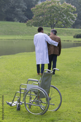 iRéeducation-infirmier aidant patient en fauteuil roulant