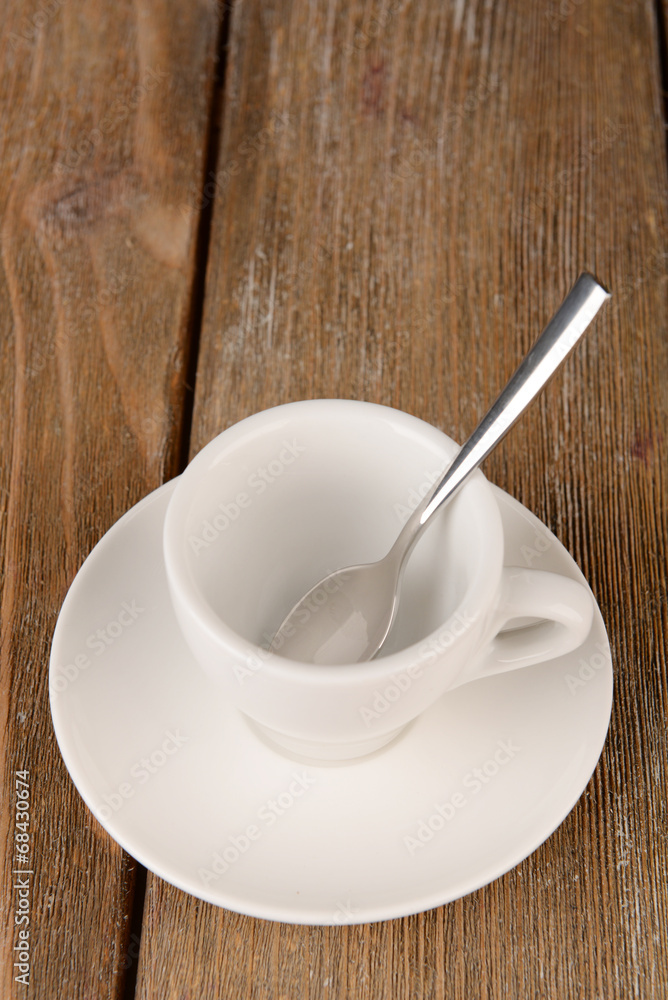 Empty cup with tea spoon on wooden background Empty cup with tea spoon on wooden background