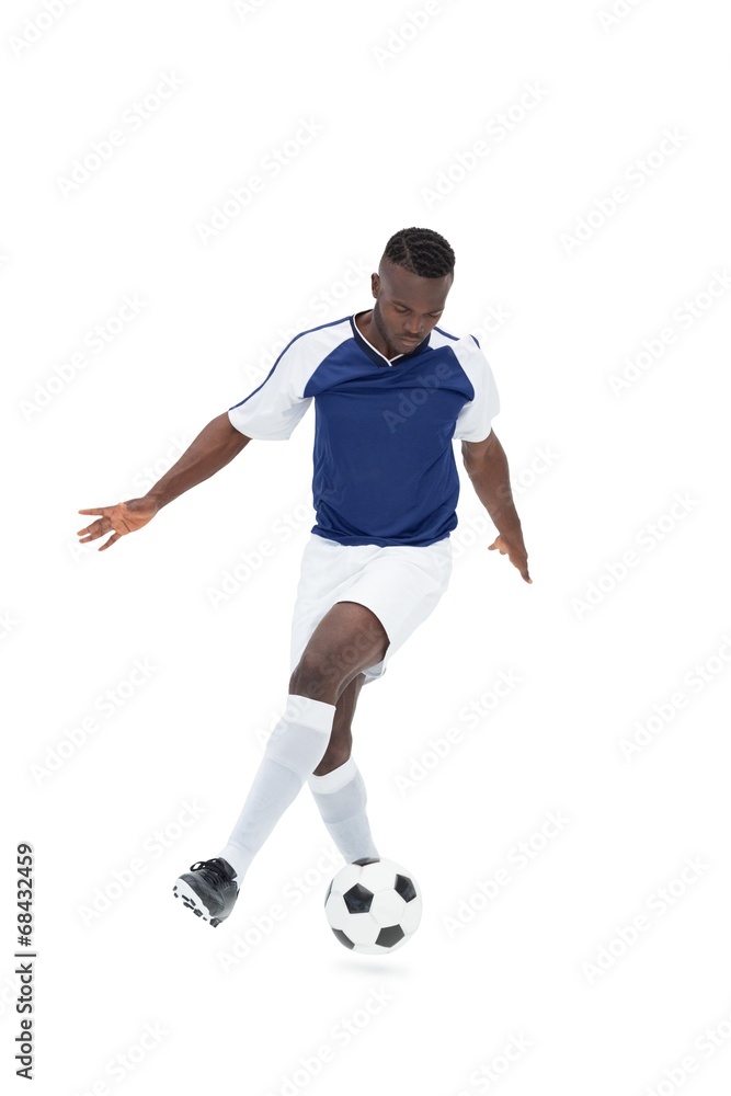 Football player in blue jersey controlling ball