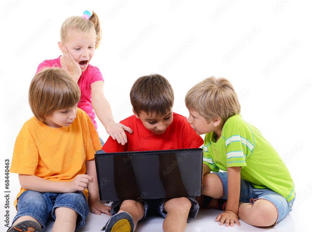 Portrait of smart schoolchildren looking at the laptop, over whi Portrait of smart schoolchildren looking at the laptop, over whi