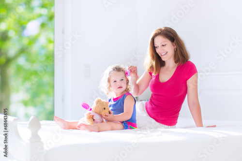 Mother and daughter brushing hair