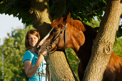 Frau mit Pferd am Baum