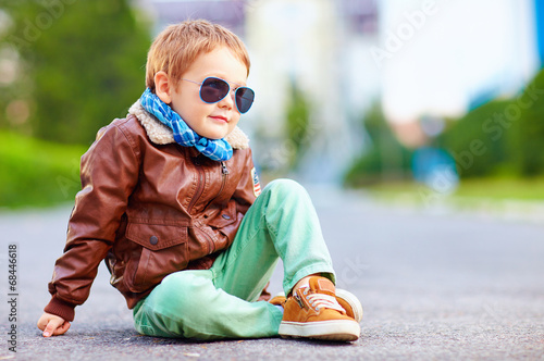 Wall Mural cute stylish boy in leather jacket sitting on the road