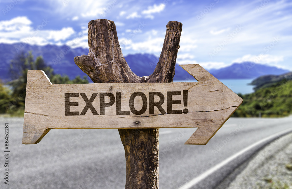 Explore! wooden sign on a road background