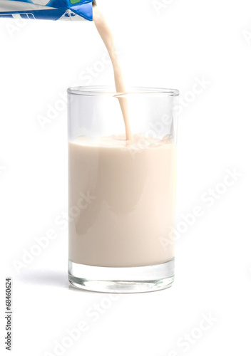 Pouring milk t into glass isolated