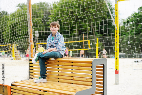 Adorable school age boy watching sport game photo