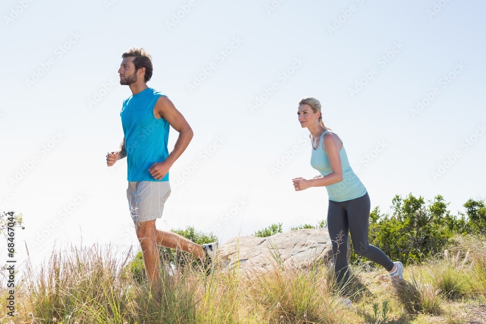 Fit couple jogging on a country trail Fit couple jogging on a country trail