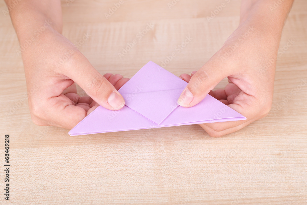 Hands making origami figure, close up Hands making origami figure, close up