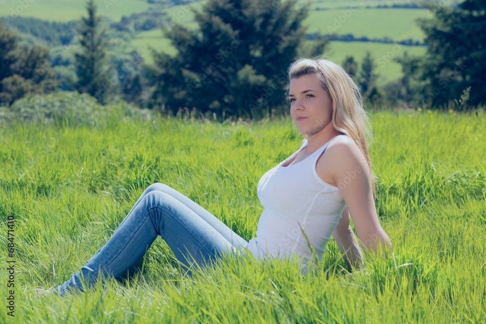 Pretty blonde thinking while sitting on grass Pretty blonde thinking while sitting on grass