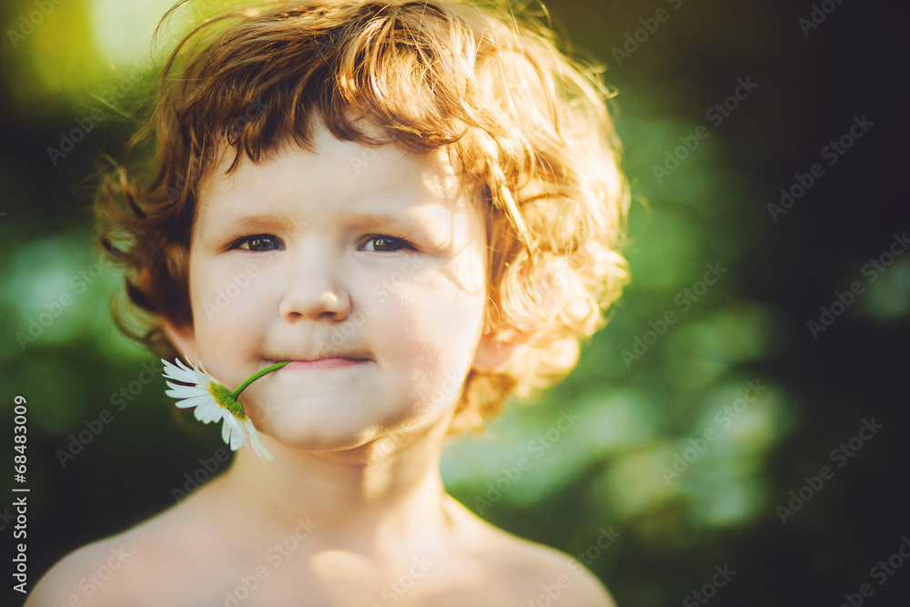 Portrait of happy child holding a daisy in his mouth. Instagram Portrait of happy child holding a daisy in his mouth. Instagram