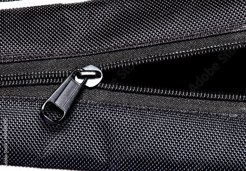 Metal zipper open on black synthetic fabric