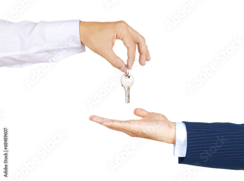 Hands of two businessman, giving and taking modern key