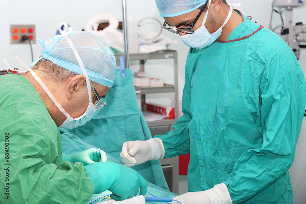 Student assistant helping doctor in a surgery Student assistant helping doctor in a surgery