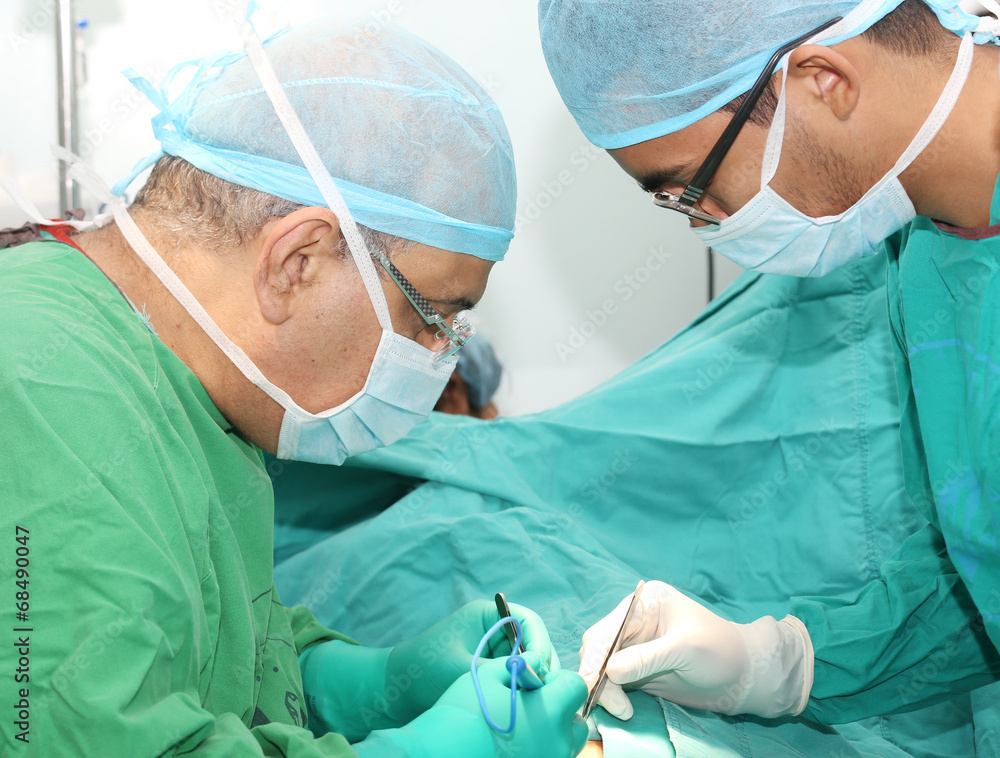 Surgeons working on a patient in operation room Surgeons working on a patient in operation room