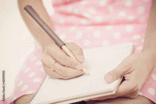 Young female is writing notes and planning her schedule