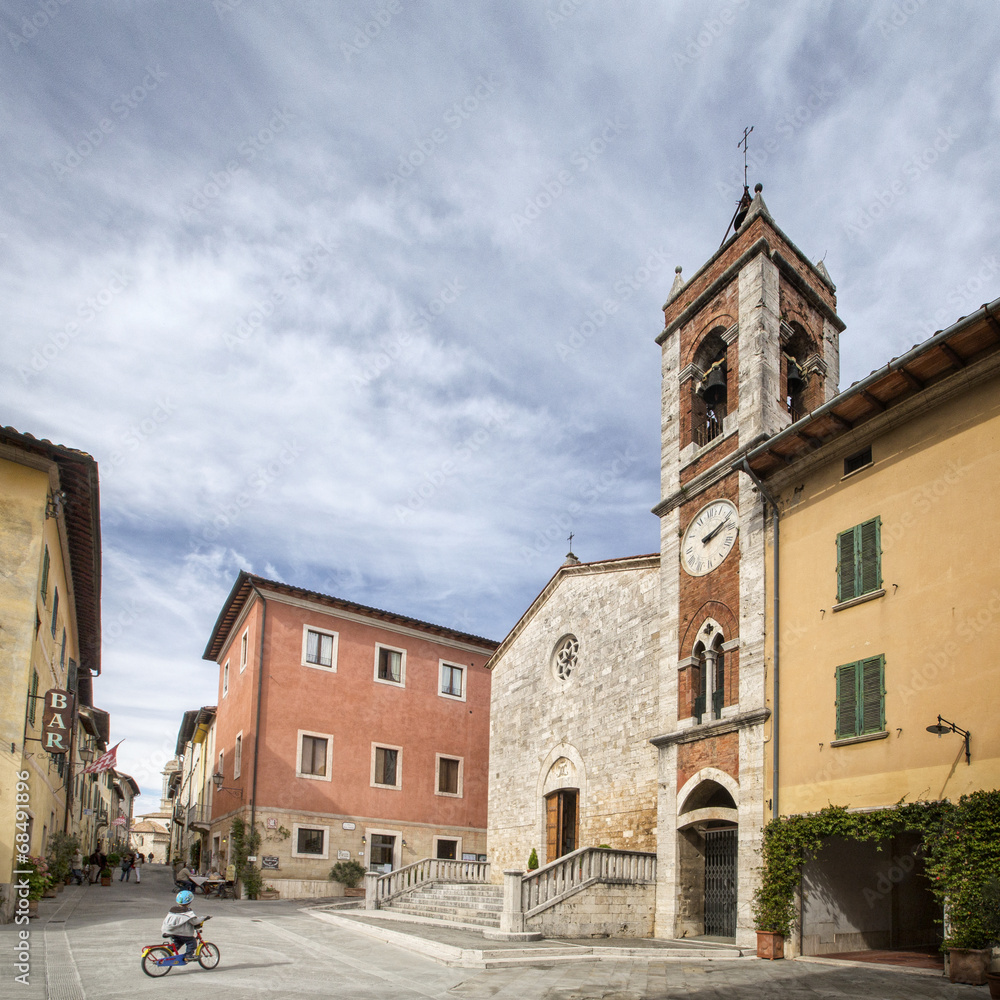 lonely square with old belfry and boy with bicycle
