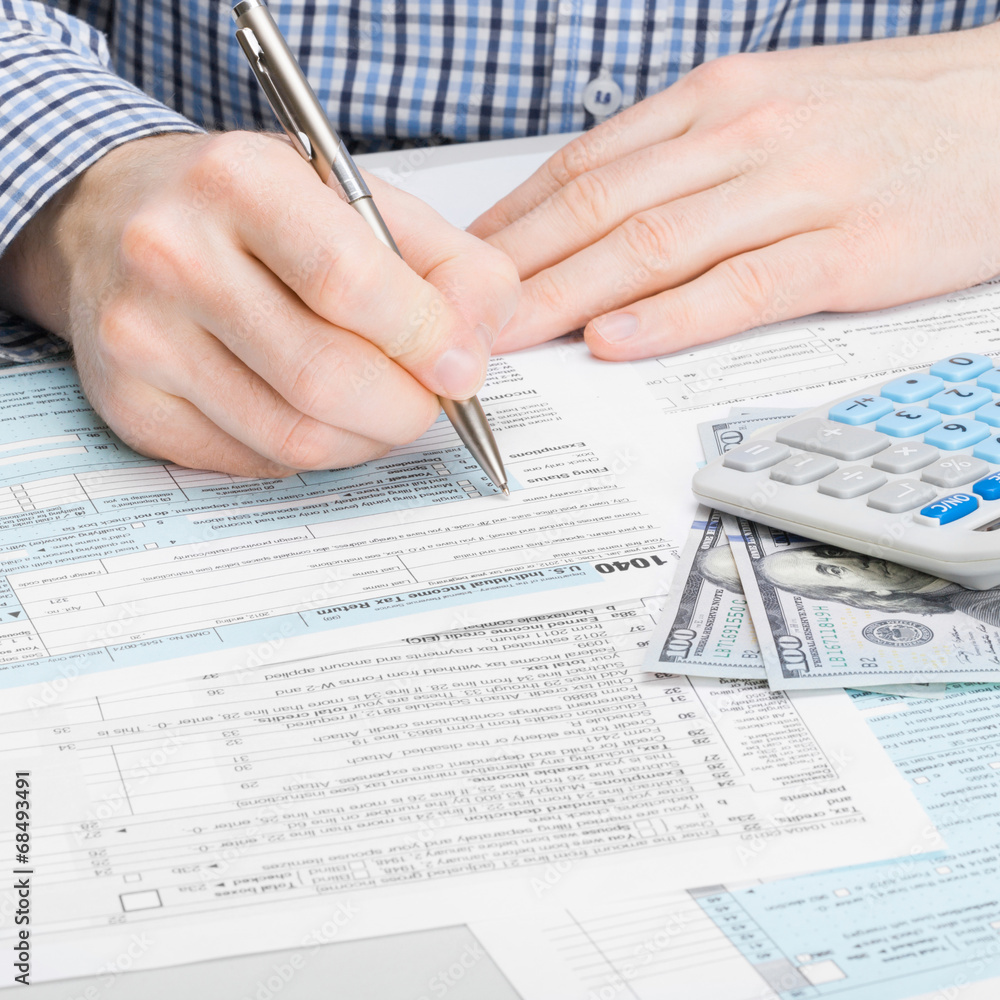 Male filling out 1040 USA Tax Form - 1 to 1 ratio Male filling out 1040 USA Tax Form - 1 to 1 ratio