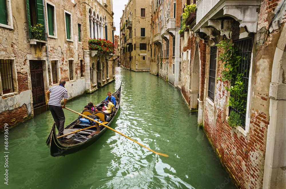 Gondola sailing on a typical Venetian water street