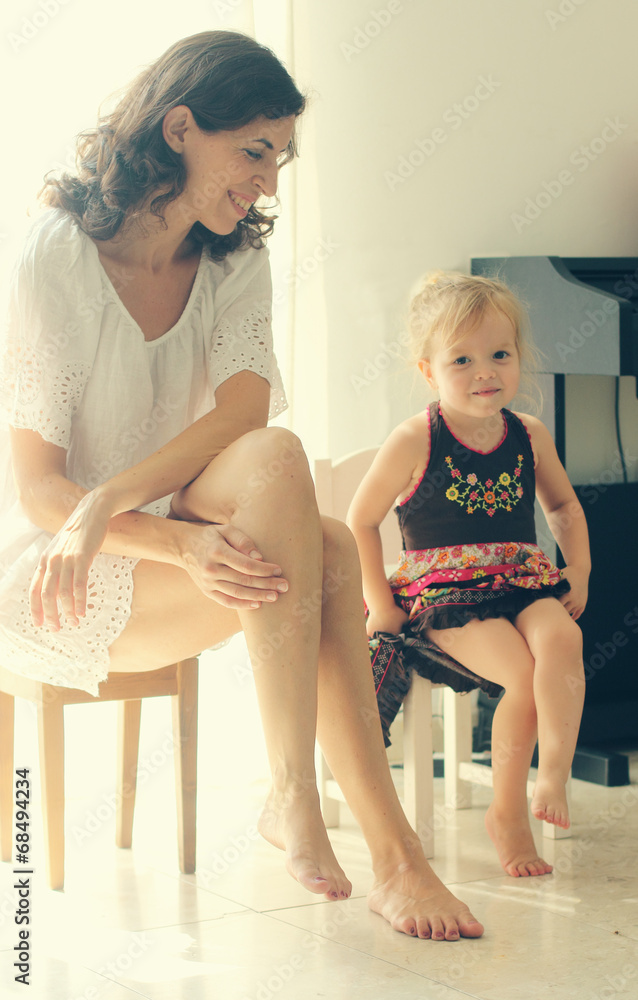 beautiful mother and daughter sitting near the window beautiful mother and daughter sitting near the window